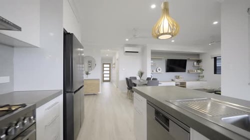 Contemporary modern open plan kitchen, dining room, lounge room. Kitchen island dark stone bench top