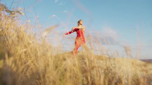 Graceful Woman Dancing Outdoors in a Red Leotard
