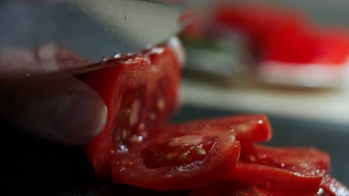 Fresh Tomato Being Sliced with a Knife