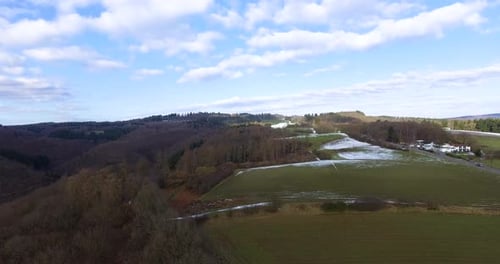 Toma con un Zumbido de campos agrícolas con algunas áreas de nieve en un día soleado de invierno.