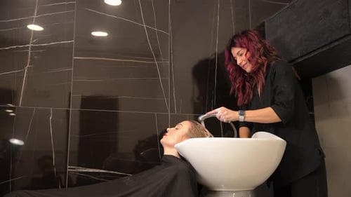 Hairdresser Washing a Client's Hair in Salon