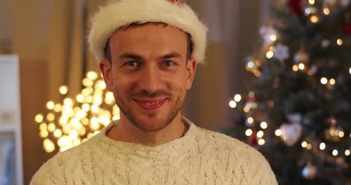 Smiling Man in Santa Hat Presents Christmas Gift