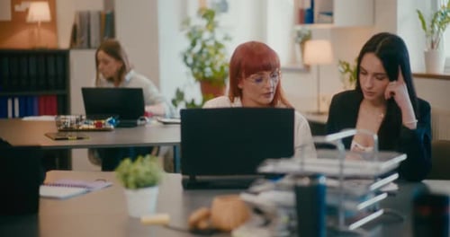 Young Coworkers Discussing at Desk in Office