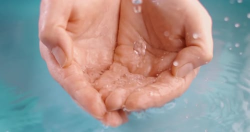 Clean drinking water flows in the palms of the woman hands. Shot on super slow motion camera 1000