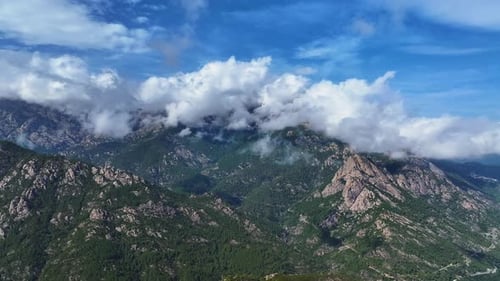 Serene mountain landscape with clouds rolling over peaks at sunset