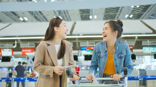 Asian young women passenger walk in airport terminal to boarding gate.