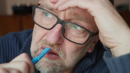 Écrivain barbu avec des lunettes dans une profonde pensée intellectuelle en gros plan
