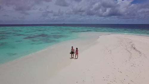Couple Walking on White Sand in the Maldives