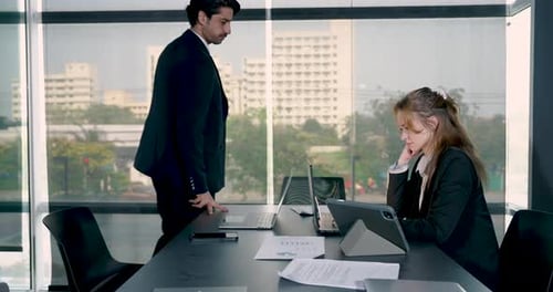 Colleagues Working at Table in Office with Laptops