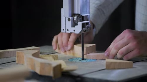 A man works with wood in a workshop. Working with wooden blanks. A man drills holes in wooden blanks