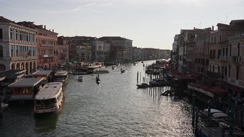 Venetian Gondolier Punting Gondola Through Green Canal Waters of Venice Italy