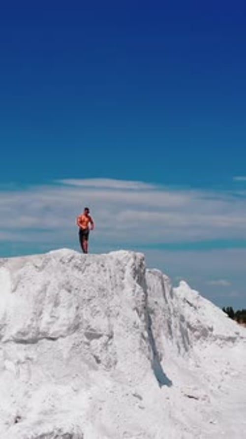 Man on Top of White Rocky Precipice