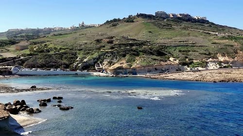 Vibrant summer day in Gozo Malta showcasing the stunning turquoise waters of a secluded bay under a
