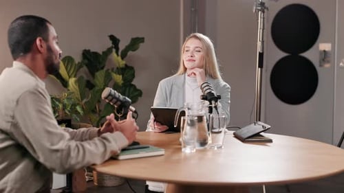 Man and Woman Recording Podcast in Modern Studio