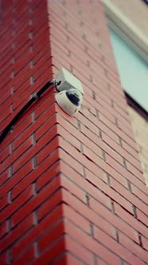 Modern Security Camera Tracking Urban Brick Building Corner Recording Surveillance Footage with