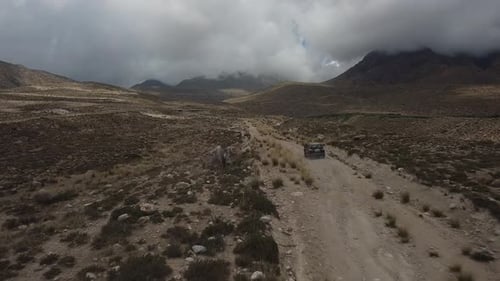 Drone : vole derrière une voiture à travers une gorge dans les montagnes du Kirghizistan