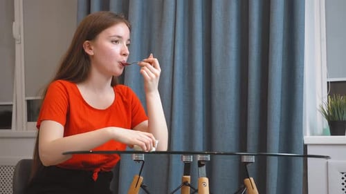 Woman Enjoys Eating Yogurt at the Table