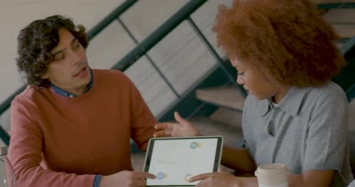 Business Professionals Discussing Data on Tablet in Meeting