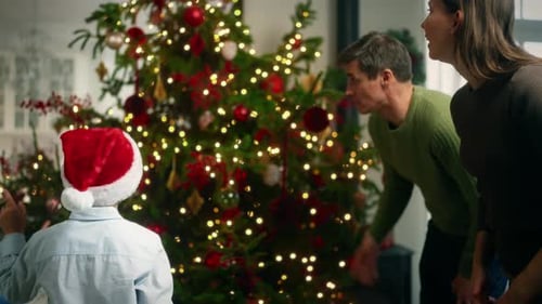 Family Decorating Christmas Tree Together in Cozy Home