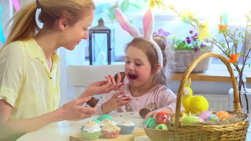 Mother and Daughter Enjoy Chocolate Eggs on Easter