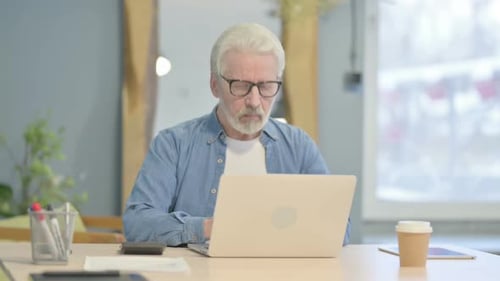 Senior Man Working on Laptop at Desk