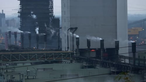Smokestacks emitting white fume at a petrochemical factory. Industrial air pollution