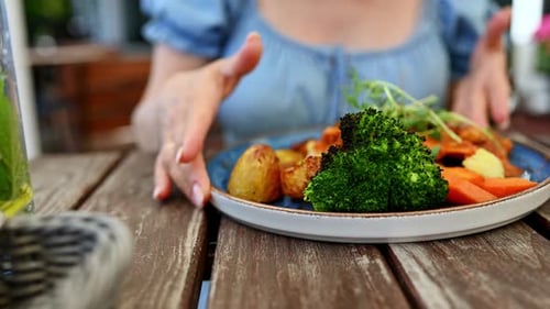 Girl Eating Vegetable Dish At Street Restaurant