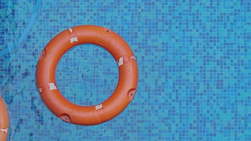El salvavidas descansa en el agua azul transparente de la piscina