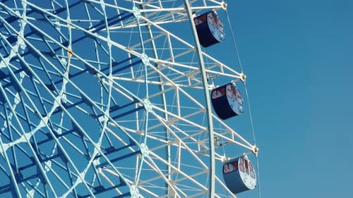 Ferris Wheel Structure Against Vivid Blue Sky