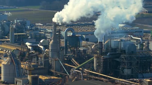 Industrial furniture factory emitting smoke from smokestacks aerial view