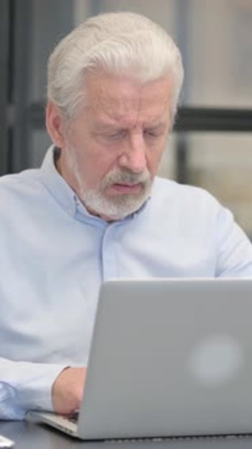 Coughing Old Businessman Using Laptop in Office, vertical video