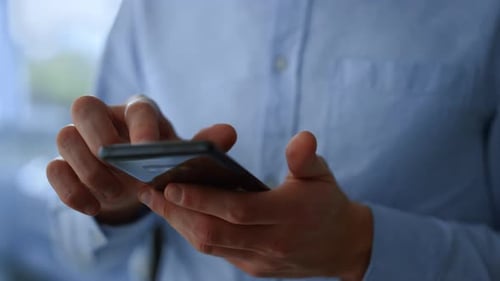 Businessman hands scrolling social media network on smartphone in office