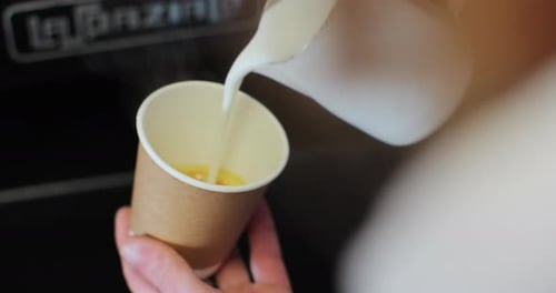 Pouring Milk into Paper Cup for Coffee