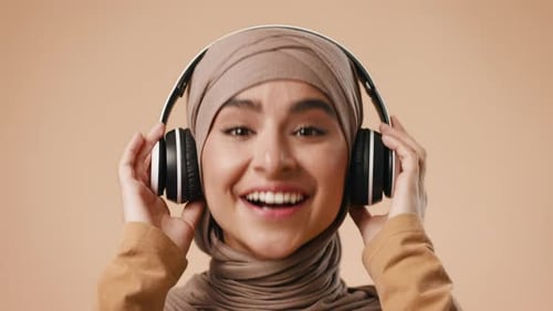 Young Middle Eastern Woman Enjoying Music with Headphones in Studio Setting