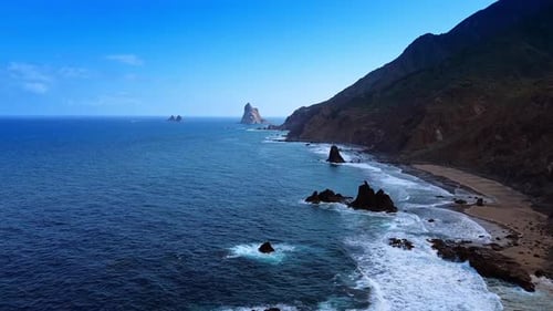 Flug über die Wasserlandschaft des Atlantischen Ozeans. Wellen rollen an die felsige Küste Teneriffas