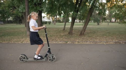 Niña montando scooter al aire libre