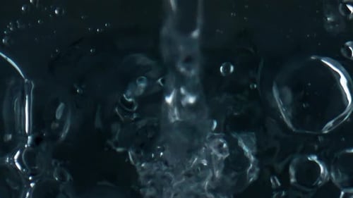 Water Pouring with Bubbles on Dark Background