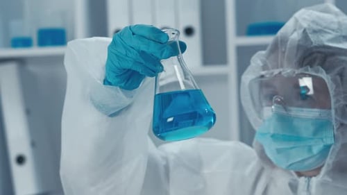 In a Lab a Scientist Analyzes a Blue Solution with Advanced Tools Conducting Microbiology and