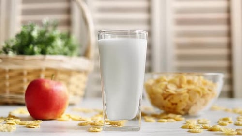 Glass of Milk with Cornflakes and Red Apple
