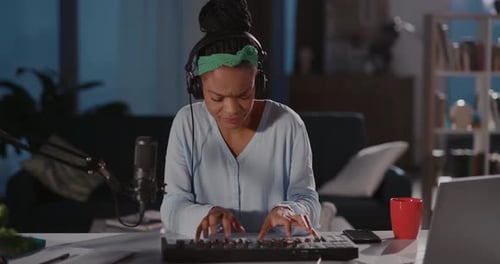 Woman Composing Music With Headphones at Night