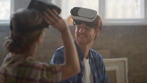Smiling Couple Wearing VR Headsets indoors