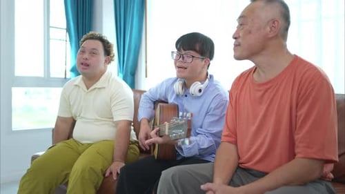 Friends Sing Along with Guitar Player Indoors