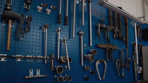 Organized tools hanging on a blue pegboard in a workshop. Perfect for DIY or industrial project visu