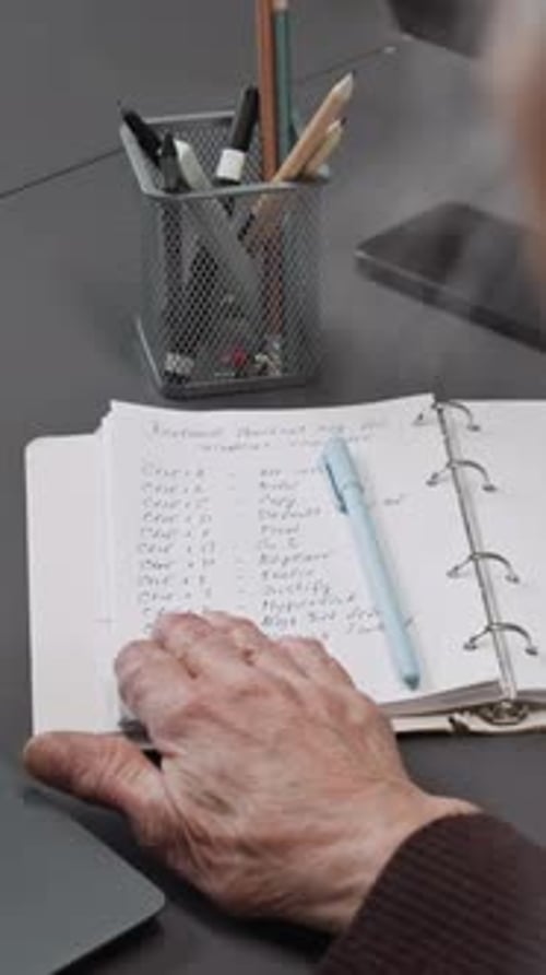 Vertical Shot of Senior Woman Looking at Notes in Computer Class
