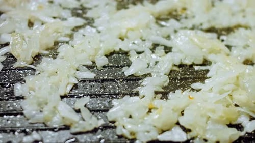 Close Up of Onions Cooking on Grill Pan