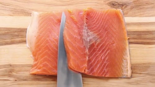 Cutting Raw Salmon on Wooden Cutting Board