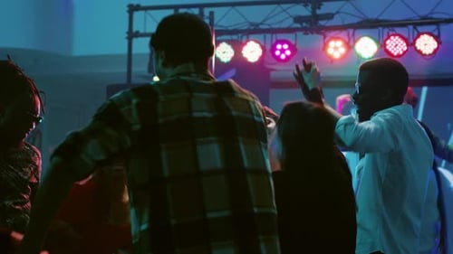 Vibrant Party Crowd Dancing Under Colorful Lights