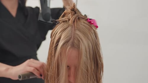 Woman Getting Hair Styled at Salon with Blow Dryer