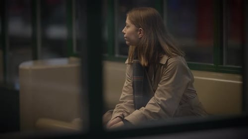 Young Woman Sitting Alone on Train at Night