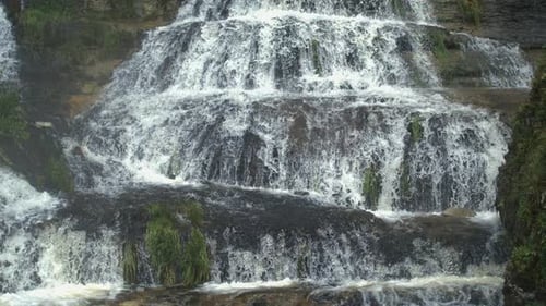 Cascading Waterfall over Rocks in a Lush Environment